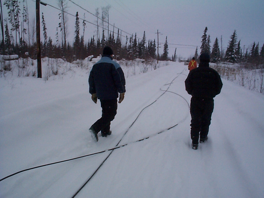 There we are checking out the wire on the ground which will go up on the telephone and hydro poles.