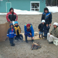 Children watch as Delia prepares duck over open flame.