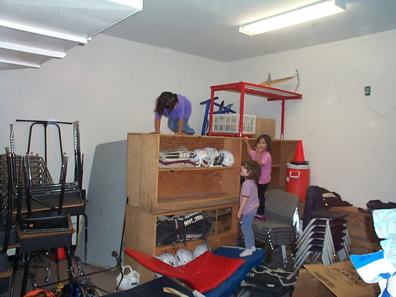 kids playing in the equipment room at the school gym.