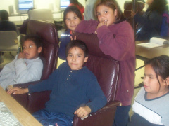 The other kids wait patiently for their turn on the computer