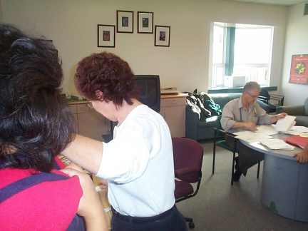 The doctor checking off names of people who had their flu shots.