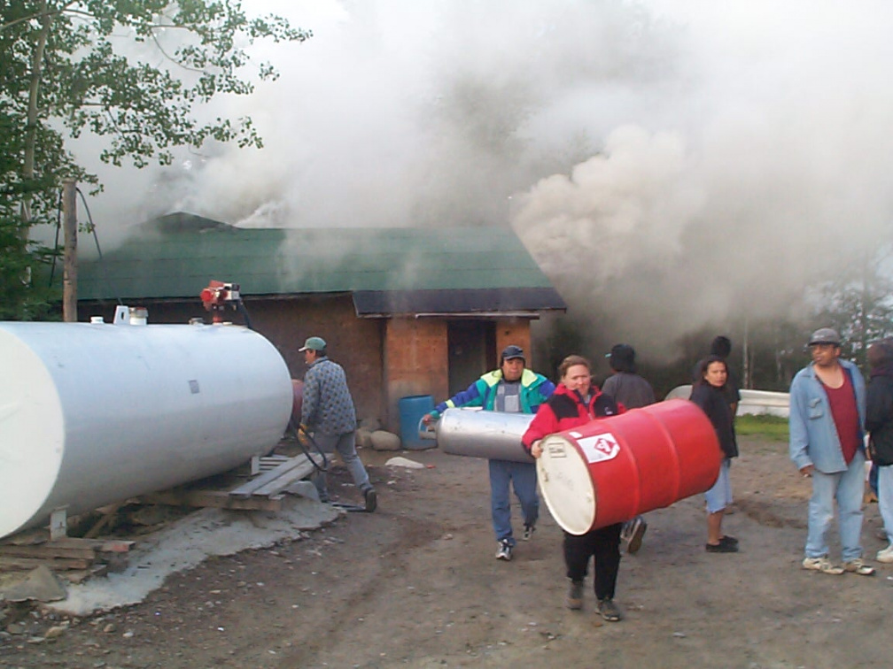 Community members moving the gas drums, and propane tanks.