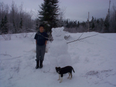 Tyler Meekis and his pupppy &quot;Lady&quot; posing for a picture with his snow scuplur.