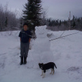 Tyler Meekis and his pupppy &quot;Lady&quot; posing for a picture with his snow scuplur.