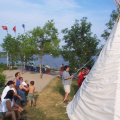 David Neegan is holding the ropes steady while they begin to work on securing the front of the tipi.