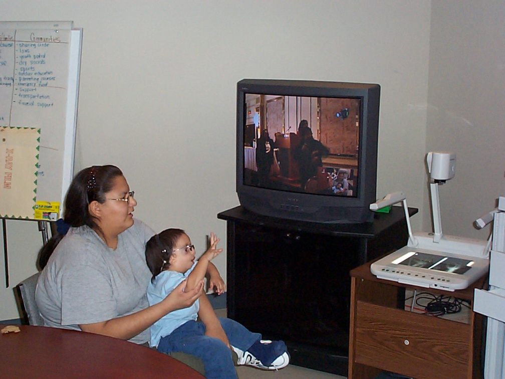 Sameul looks on as his grandma Julie (shown on video) while she is presenting at the Thunder Bay Conference.