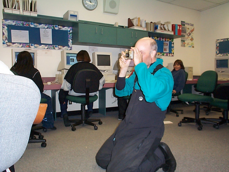 this guy is taking photographs for the of the students in the computer class. Hey i forgot your passwords for your website.