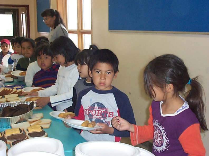 Grade one, getting served, hamburger, bannock dogs, pops, chips, and juice.