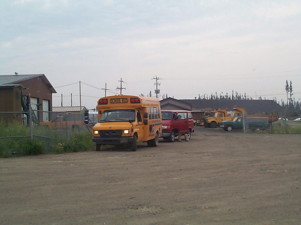 The school bus sits close by the airport, with the medical van right behind it.