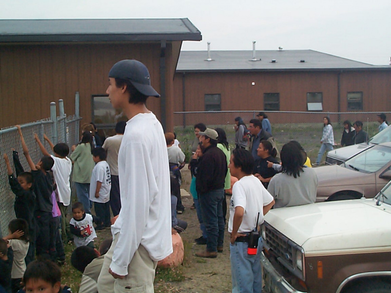A picture of the community members watching the plane.