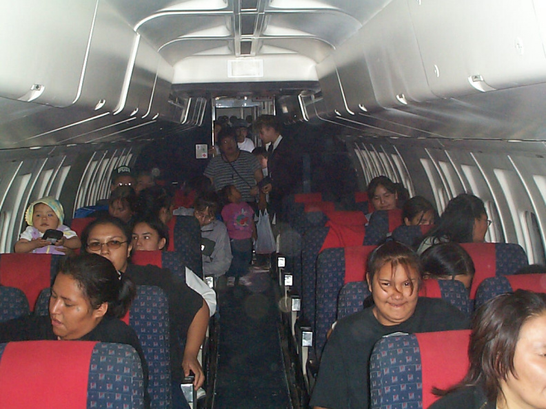 A picture taken from the front of the plane as they were all seated.
