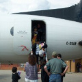 here we have a lot of people waiting for the passengers to get off the plane. I bet u they brought a lot of stuff.
