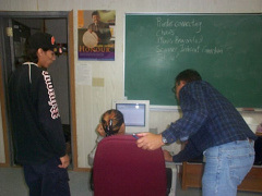 Ferdi Vanzyl (KiHS Teacher)assists a student while James Rae (assistant) are helping looks on.
