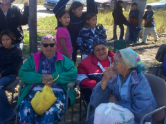 Local elders wait in the shade for the ceremony to begin.