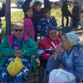 Local elders wait in the shade for the ceremony to begin.