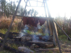 see the meat hanging on the rack, being smoked