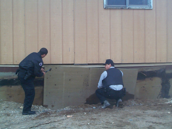 Checking the width, and putting it down before Constable Richard Roy nails the board down in place.