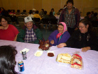 Some elders sitting at the table
on the left is Kenny and his sister Susan inspecting the pigs head.