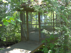 The screened-in gazebo on the other side of the stream