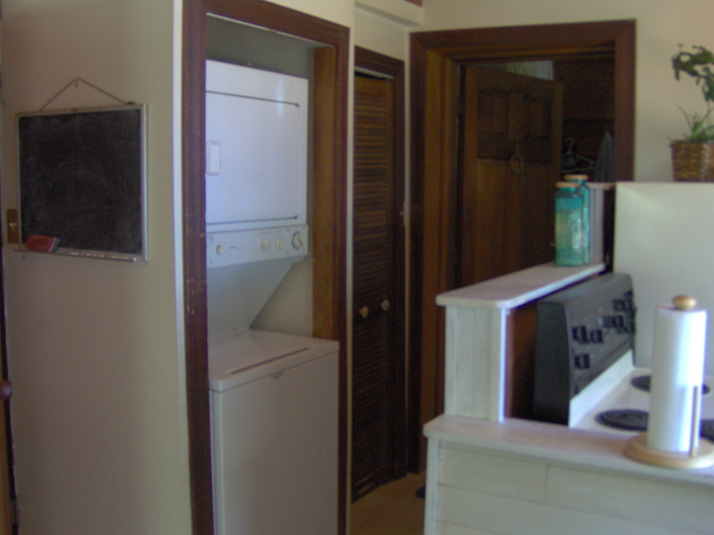 The hallway with the washer and dryer with the doorway to the entrance that leads to the other two bedrooms