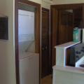 The hallway with the washer and dryer with the doorway to the entrance that leads to the other two bedrooms