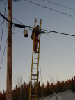 A Blair Electronics worker installing a cable amplifer on a pole near the Deer Lake school.