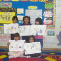 K-4 girls proudly showing their artwork.