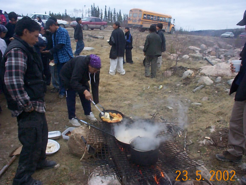 Grady Kakegamick looking at one of the elders (Maragaret Sawanas) while she cooks fries for the fish