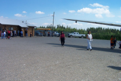 A shot of the wing of the airplane and further down is the airport terminal