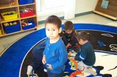 Benjamin poses for the camera. Tyreek and Hayden are playing with the dinosaurs.