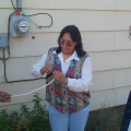 E-Centre manager Darlene rae cuts the end of the white cable to connect to the internet. On the right you can just see one happy