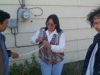 E-Centre manager Darlene rae cuts the end of the white cable to connect to the internet. On the right you can just see one happy