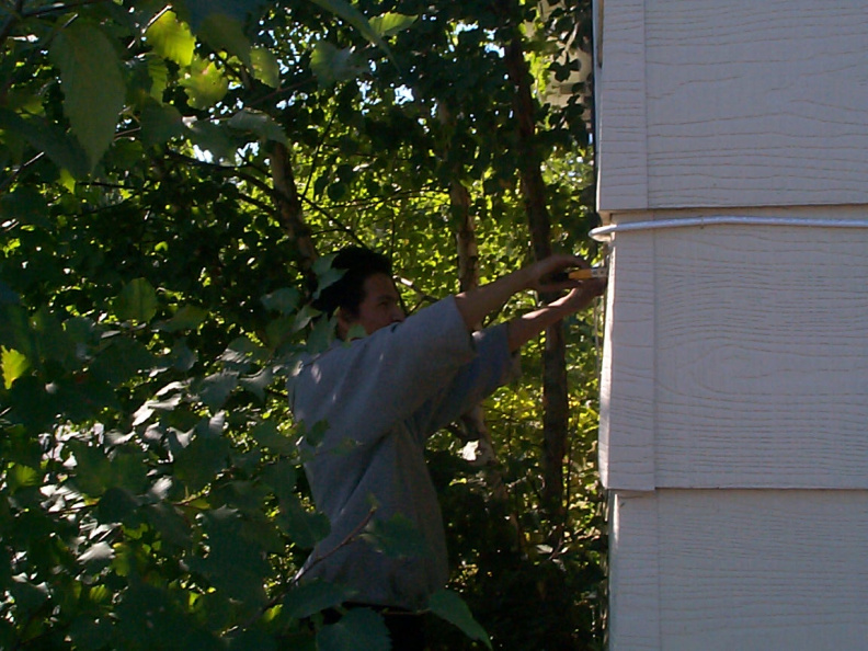 Arnold Thompson doing some manual labour, stapling the cable along the wall.