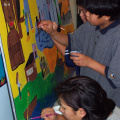 Bottom Left: Ruth Wassaykeesic (grade 9) takes a moment to help the grade 6/7 students with their mural.