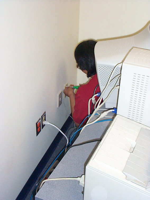 Darlene Rae installing a wall plate with network connector.