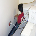 Darlene Rae installing a wall plate with network connector.