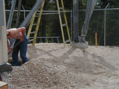 Pat digs out the corners of the base to lay down the grounding cable and rods to deal with potential lightening strikes