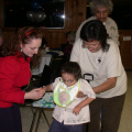 The little man of the hour, Samuel Meekis, being presented with a bright, red wagon by Dr. Teresa Bruni.