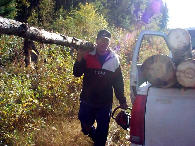 well here's Andy carrying a log on one shoulder and carrying the chainsaw