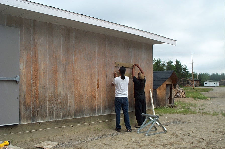 Cal Kenny and Ron Michitimy bolting the mount base to the south wall of the school.